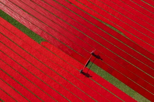Photograph Azim Khan Ronnie Drying Red Fabrics on One Eyeland