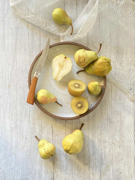 Photograph Ann Cutting Pears And Kiwi on One Eyeland