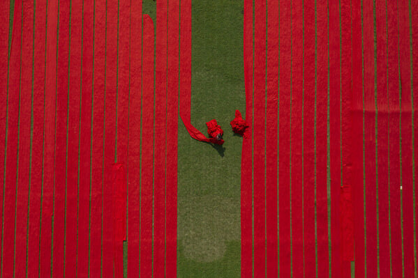 Photograph Azim Khan Ronnie Drying Red Fabrics on One Eyeland