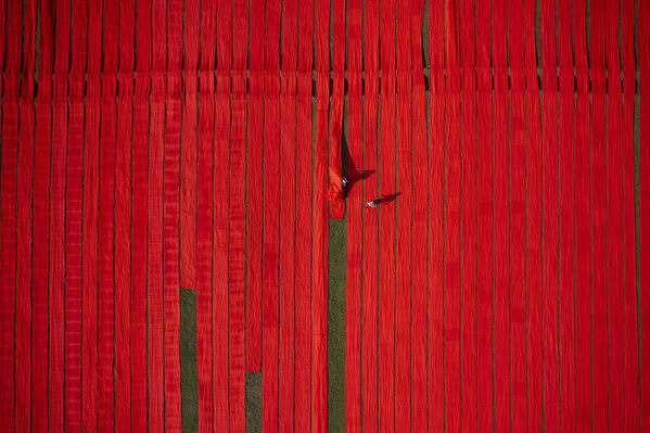 Photograph Azim Khan Ronnie Drying Red Fabrics on One Eyeland