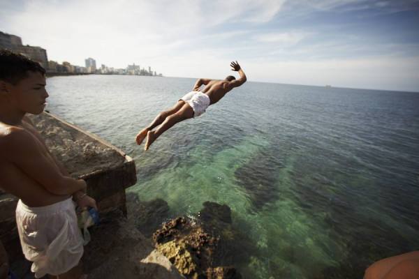 Photograph Dennis Welsh Diving Off The Wall On The Malecon In Havana on One Eyeland